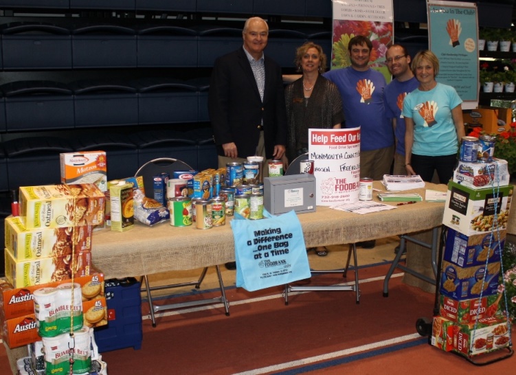 Freeholder John P. Curley (left) and FoodBank of Monmouth and Ocean Counties Board of Trustees member Leslie Barlow (far right) were on hand at the Made in Monmouth expo to collect food donations for the County-wide food drive. There is still time to donate at many County locations.
